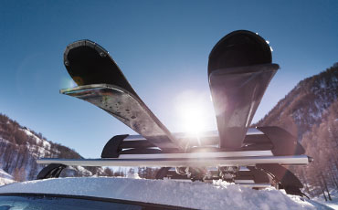 Skidor fastspända på ett biltak